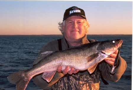 Gary Engberg the author hoists a huge December Walleye out of Lake Erie